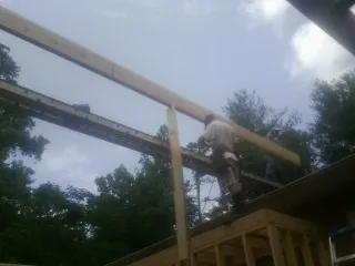Carpenter setting a ridge beam over a new addition frame — Ice Dam Removal by Roofing Brothers in New Alexandria