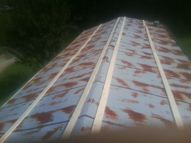 Rusted metal roof panels with new wood purlins before replacement — Storm Damage Roof Repair in New Alexandria by Roofing Brothers
