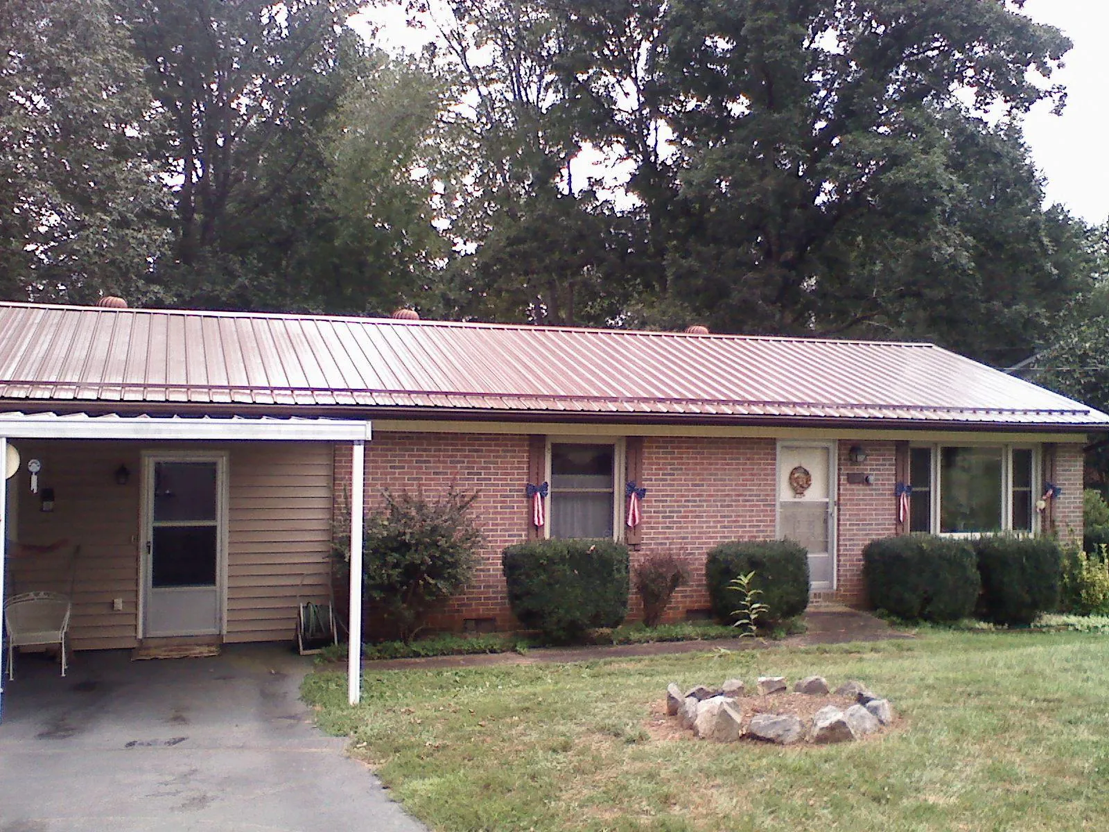 Bronze metal roof and carport on a brick ranch home — Roof Repair work by our crew in New Alexandria