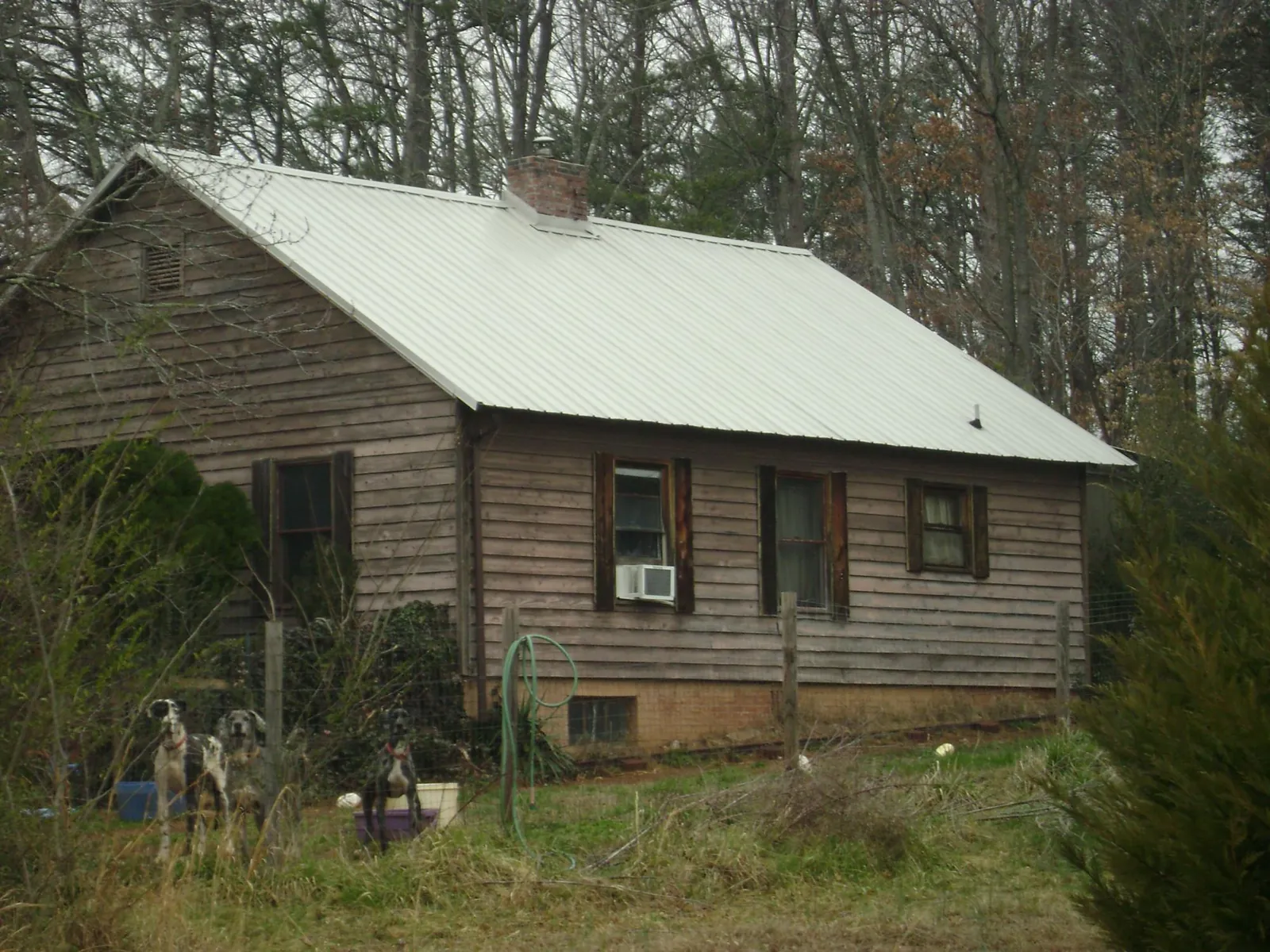 White metal roof on an old wood sided farmhouse, from a Metal Roof Installation job in New Alexandria